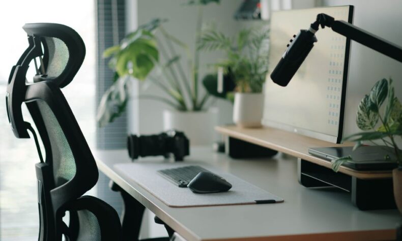 Stylish home office setup with ergonomic chair, plants, and tech accessories creating a modern work environment. - Photo by Alpha En on Pexels