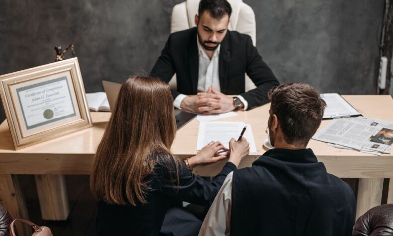 A lawyer discusses legal documents with clients in an office setting. - Photo by Pavel Danilyuk on Pexels