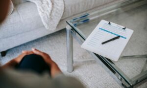 From above of blurred unrecognizable female psychologist sitting in office near table with clipboard and pen during session in office - Photo by Alex Green on Pexels