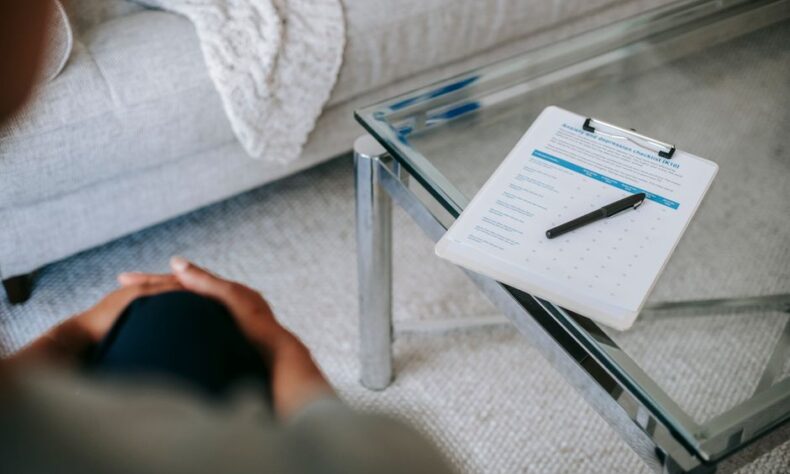 From above of blurred unrecognizable female psychologist sitting in office near table with clipboard and pen during session in office - Photo by Alex Green on Pexels