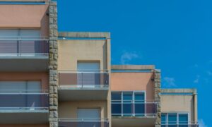 Modern apartment building with balconies against clear blue sky. Urban architecture scene. - Photo by Jan van der Wolf on Pexels